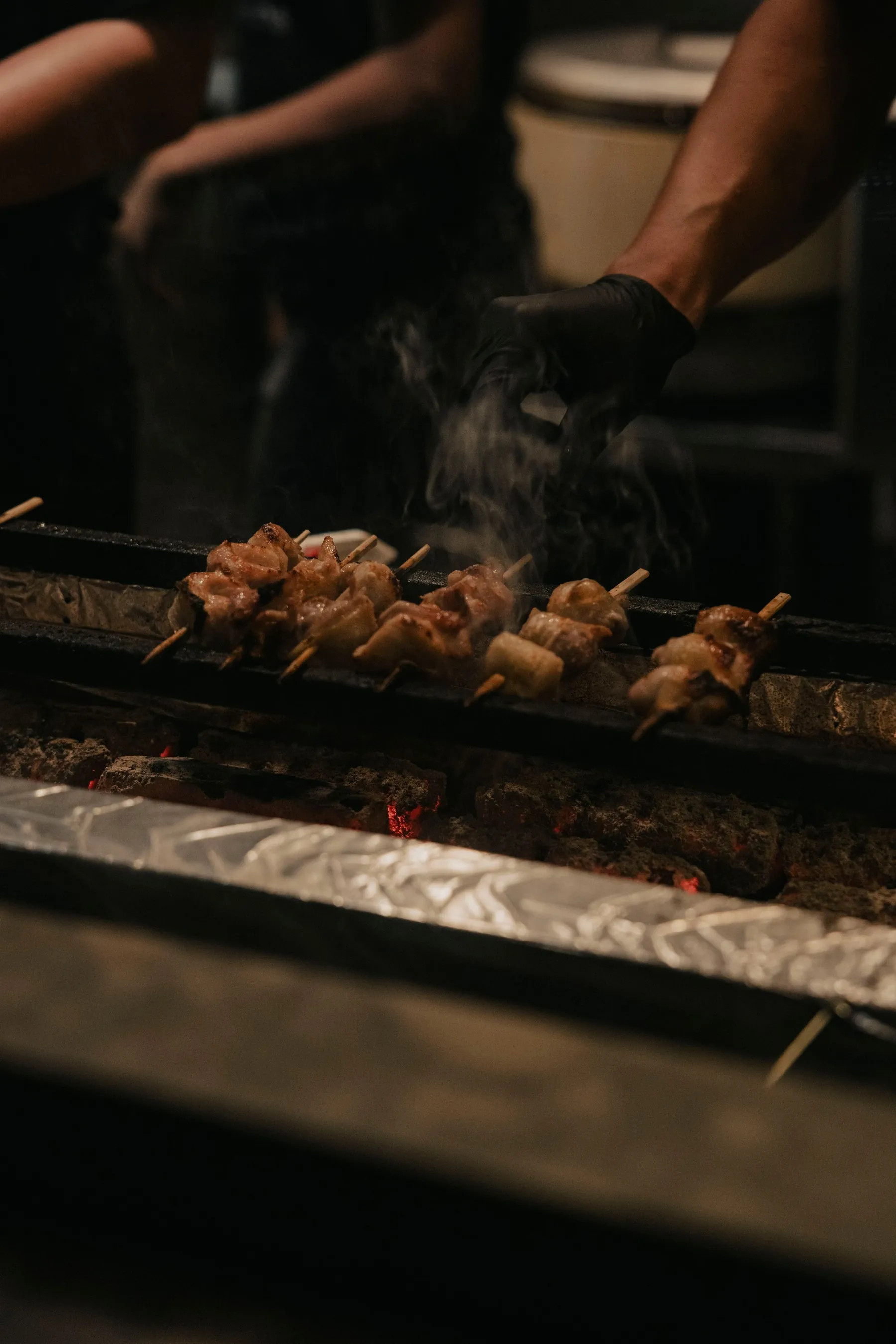 Skewers turning over glowing coals on the grill